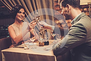 Stylish wealthy couple toasting with champagne