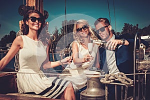 Stylish wealthy friends having fun on a luxury yacht photo