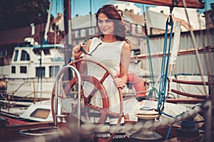 Stylish wealthy woman on a luxury wooden regatta