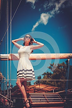 Stylish wealthy woman on a luxury wooden regatta