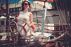 Stylish wealthy woman on a luxury wooden regatta