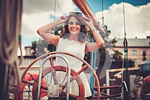 Stylish wealthy woman on a luxury wooden regatta