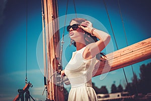 Stylish wealthy woman on a luxury wooden regatta