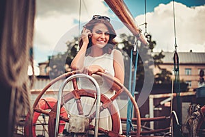 Stylish wealthy woman on a luxury wooden regatta