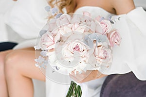 Stylish wedding bouquet of delicate pink roses in the hands of the bride close-up