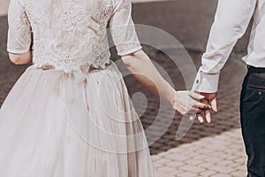 Stylish wedding bride and groom walkingn in sunny park, happy mo