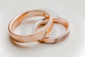 Stylish wedding pink gold rings on white background