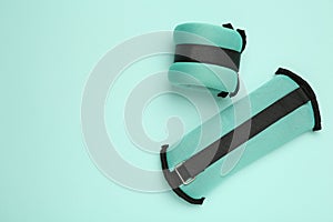 Stylish weighting agents on turquoise background, flat lay. Space for text