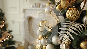 Stylish white christmas interior with decorated fir trees, fireplace, lanterns, lamps, candles, wreath, bumps and gifts