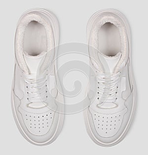 stylish white female sneakers with laces isolated on a white