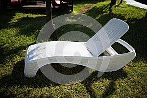 Stylish white lounger made of plastic on the lawn.