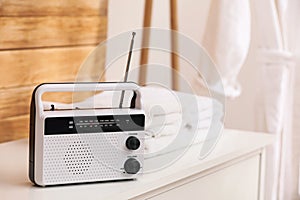 Stylish white radio on table in bathroom, space for text