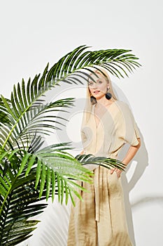 Stylish woman amidst lush green palm leaves