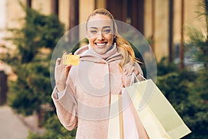 Stylish woman holding colourful bags and credit card