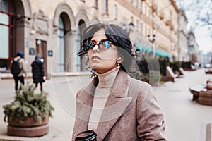 Stylish woman listning music on her airpods in city