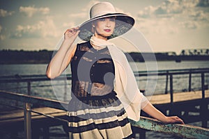 Stylish woman on old wooden pier