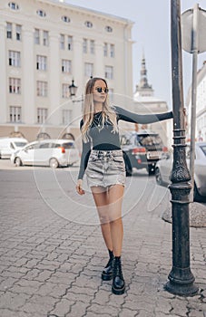 Stylish young woman posing in the street, wearing denim skirt. Fashion summer photo photo