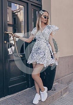 Stylish young woman posing in the street, wearing white dress. Fashion summer photo photo