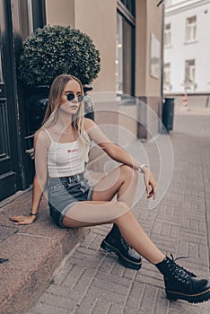 Stylish young model posing in the street, wearing sunglasses. Fashion summer photo photo