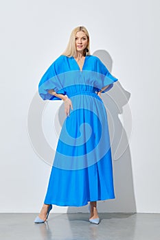 Stylish woman posing in vibrant blue dress