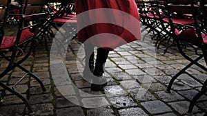 Stylish Woman In Red Skirt Strolls Through Outdoor Cafe On Historic Street