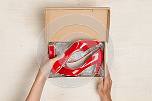 Stylish woman`s shoes in a box on wooden background