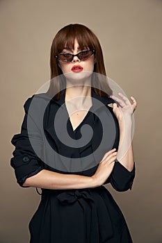 Stylish Woman Sunglasses beige background black coat