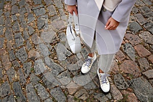 Stylish woman with trendy white baguette bag on city street, closeup