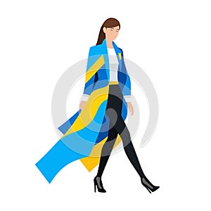 Stylish woman walking confidently in blue and yellow coat. Modern fashion, confident female stride. Empowered