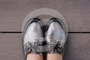 Stylish women`s leather shoes with laces on a wooden board, contrasting objects