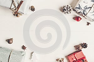 stylish wrapped present boxes with ornaments on white wooden background top view, space for text. christmas flat lay. seasonal gr