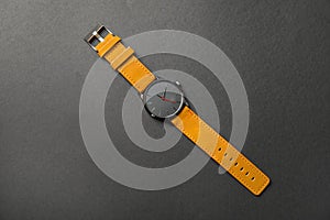 Stylish wrist watch on dark background, top view