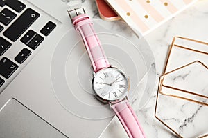 Stylish wrist watch and laptop on office table