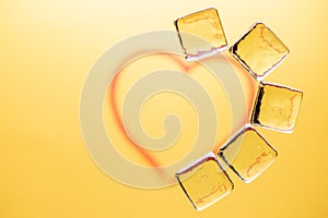 Stylish yellow background with transparent ice-like cubes for drinks. Flat lay macro photo