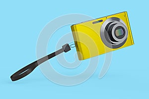 Stylish yellow compact pocket digital camera isolated on blue background