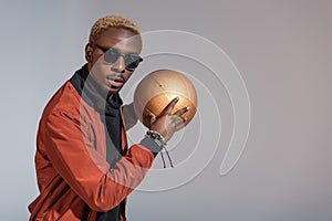 Stylish young african american man with basketball ball in hands