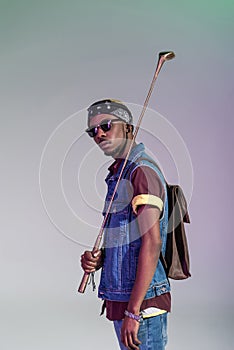 stylish young african american man holding golden golf club and looking at camera