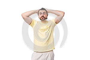 stylish young brunette man in a yellow t-shirt on a white background with copy space