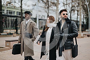 Stylish young business professionals walking in city for outdoor meeting.