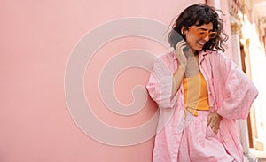 Stylish young caucasian woman poses averting her gaze at pink wall with place for text. photo