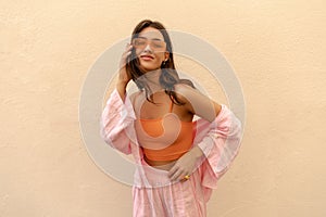 Stylish young caucasian woman in sunglasses looking at camera with good mood.