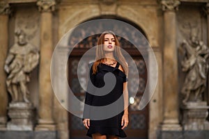 Stylish young girl in a black dress on the street of the city of BRNO in the morning.Czech