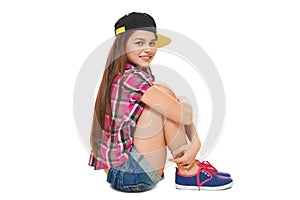 Stylish young girl in a cap, a shirt and denim shorts. Street style teenager, lifestyle, isolated on white background