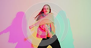 Stylish young girl, cool dancing in colorful neon light. Dance school advertising video