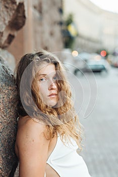 A stylish young girl with curly hair in a side portrait