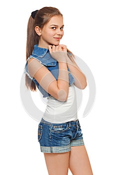 Stylish young girl in a jeans vest and denim shorts. Street style teenager, lifestyle, isolated on white background