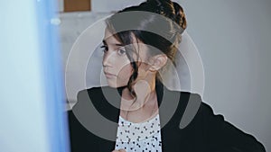 Stylish young girl willingly works with computer in office. 4K