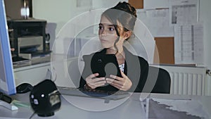 Stylish young girl willingly works with computer in office. 4K