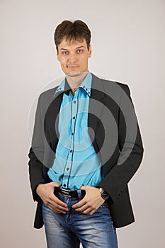 stylish young guy in jeans, a blue shirt and a black jacket