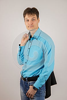 stylish young guy in jeans, a blue shirt and a black jacket